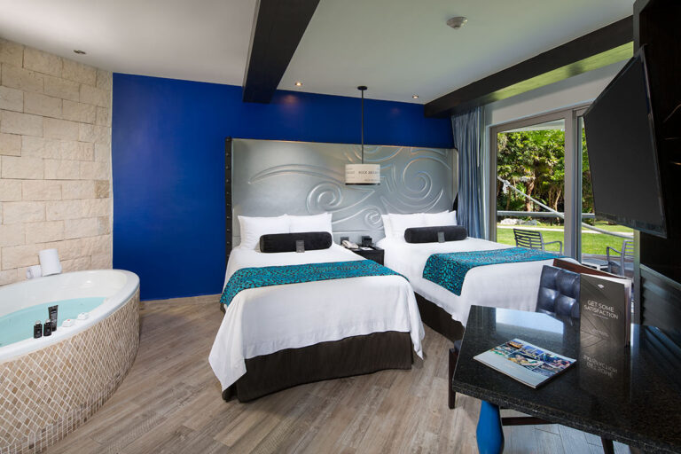 The interior of a Deluxe Gold double bed room with jacuzzi and open patio view.