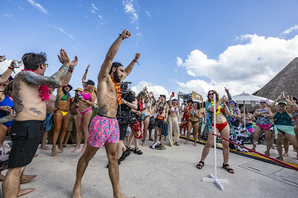 Guest with his hands up during a poolside limbo activity.