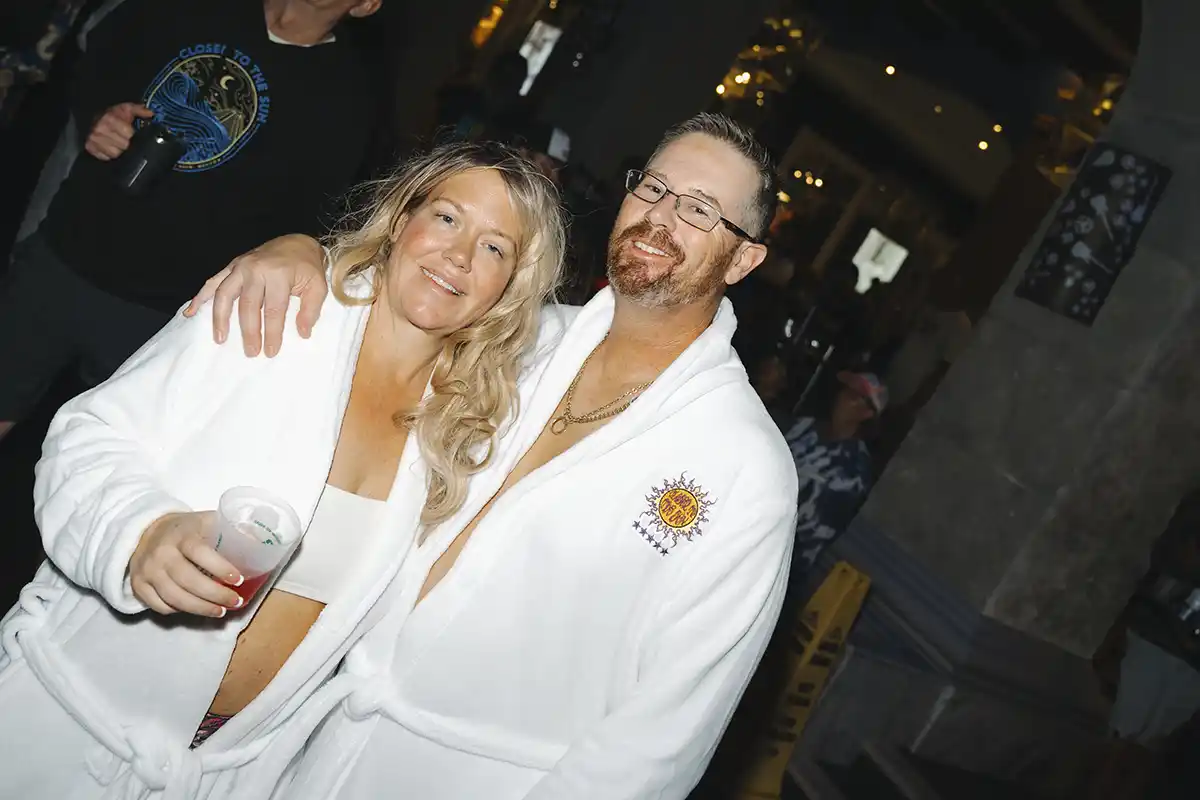 Guests posing in white robes given as a loyalty gift.