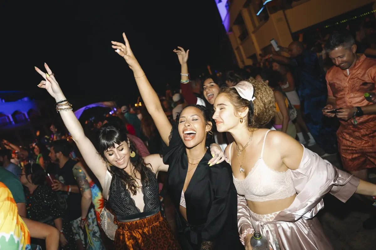 Guests posing with their hands up in theme night costumes.