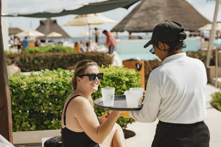 Resort Staff bringing a guest a drink by the pool.