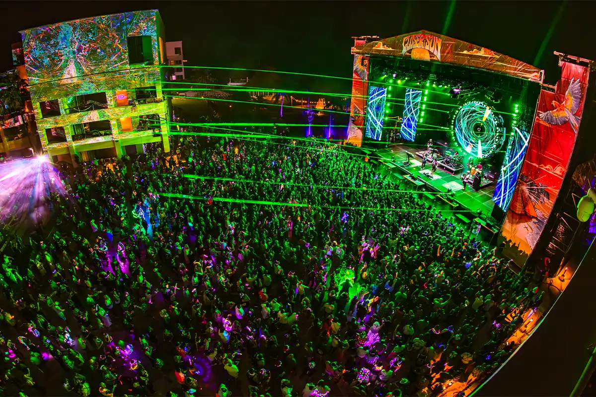 An aerial view of the main stage crowd, with lasers shining across the sky.