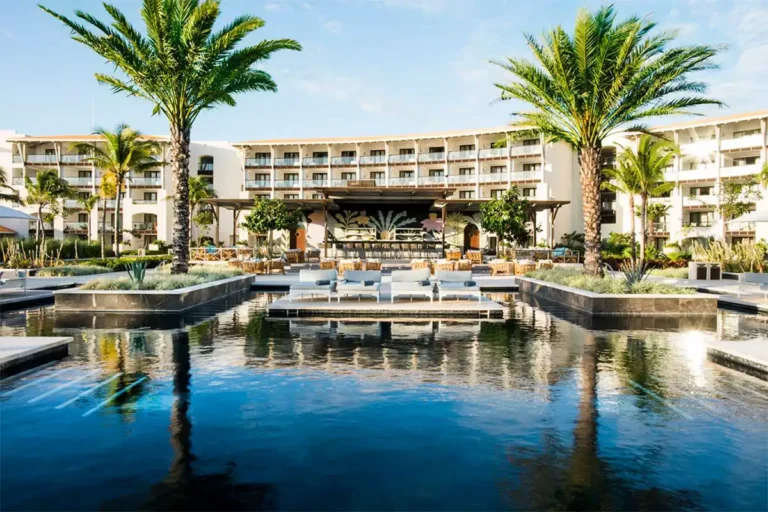 A pool with lounge chairs next to it.