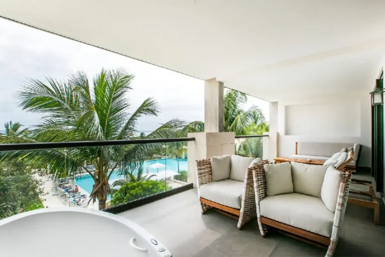 A balcony with lounge chairs and a jacuzzi.