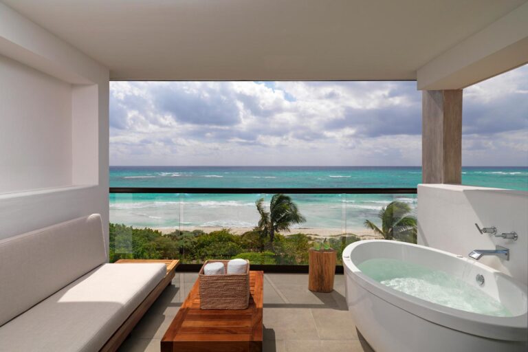 Balcony overlooking the beach with lounge chairs & jacuzzi.