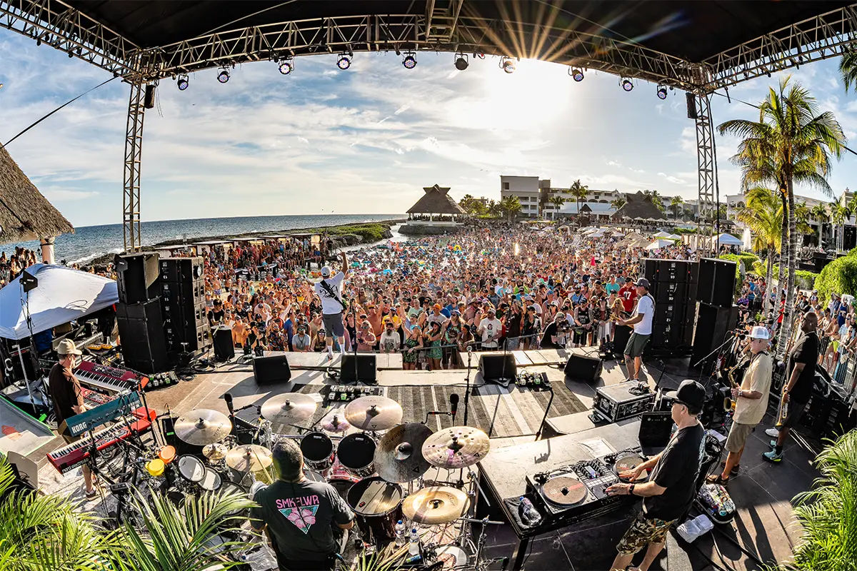 Behind the band view of the Beach Stage looking out towards the crowd in a lagoon.