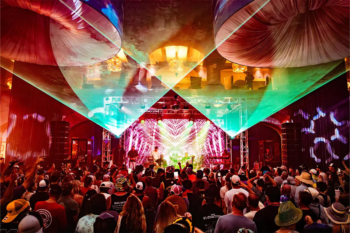 Indoor Heaven Lobby stage during a Slightly Stoopid acoustic set. Lasers shine above the crowd.