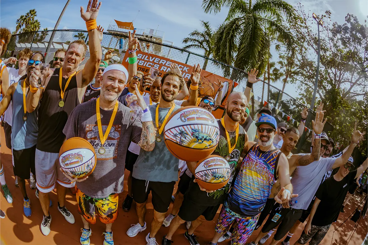Basketball tournament champions holding their prized Closer To The Sun branded basketballs.