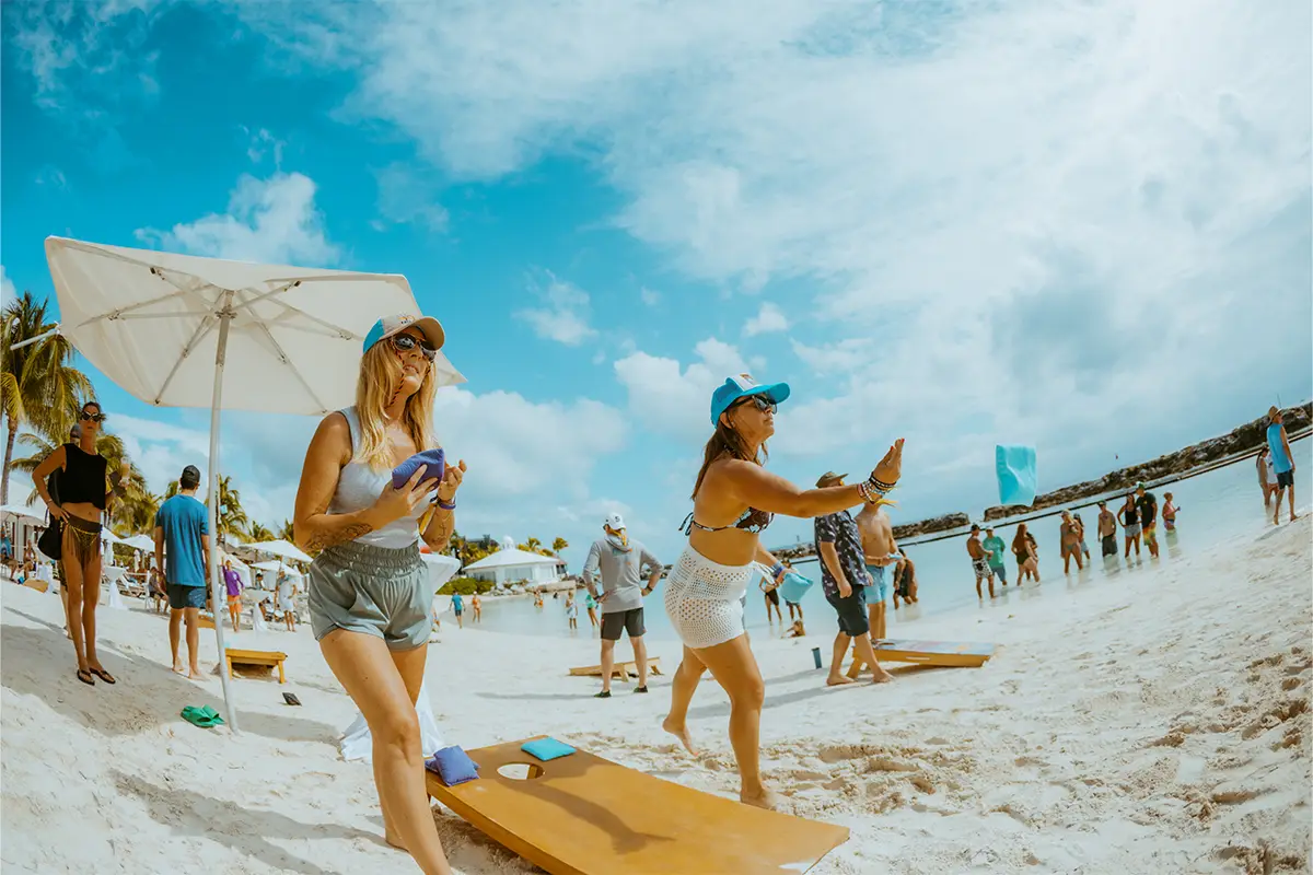 Guests playing cornhole on the beach.