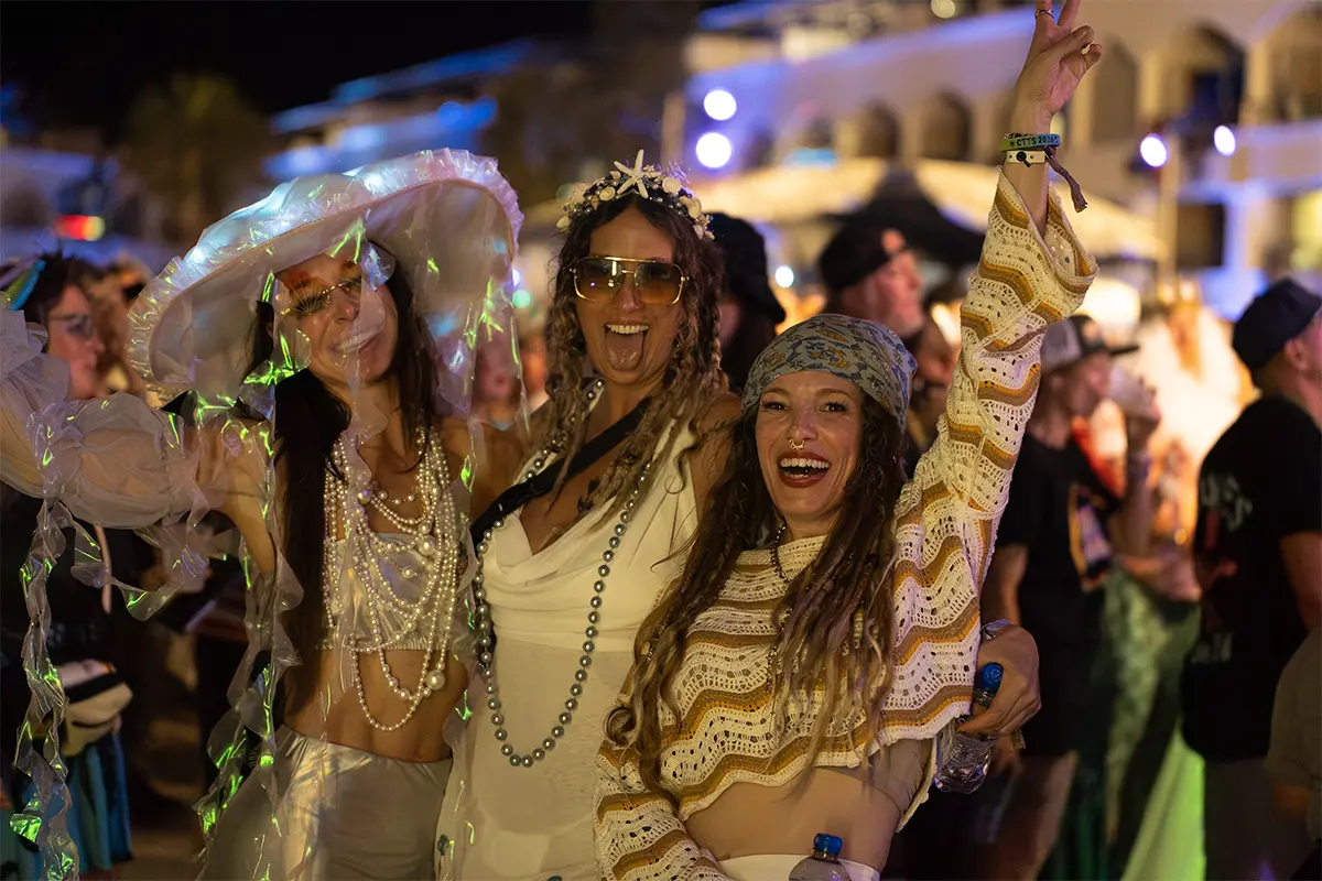Guests posing with their hands up in theme night costumes.